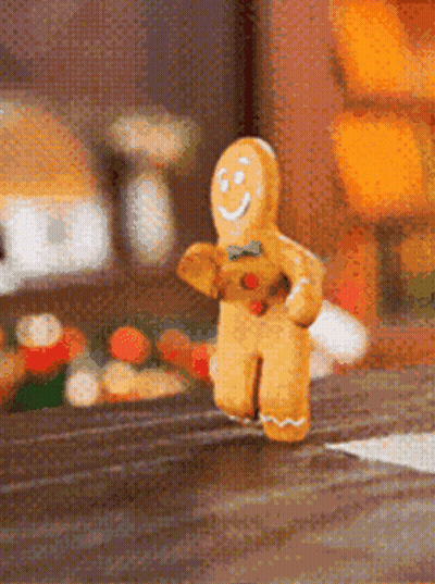 A Gingerbread Man Is Running Down A Street GIF