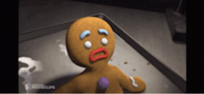 A Gingerbread Man Is Sitting On A Tray With A Sad Look On His Face GIF