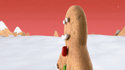 A Gingerbread Man Standing In The Snow With A Red Nose GIF