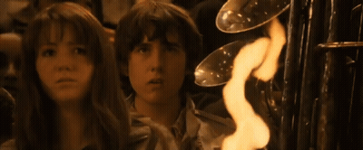 A Girl And A Boy Are Looking At A Fire GIF