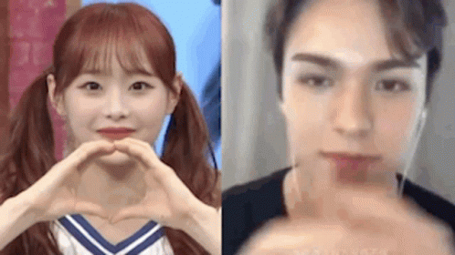 A Girl And A Boy Are Making A Heart With Their Hands . GIF