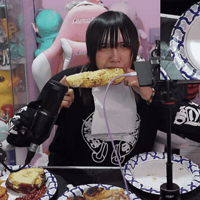 A Girl Eating Corn On The Cob With A Purple Cord GIF