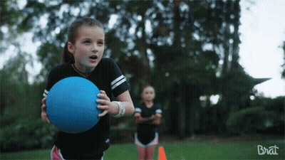 A Girl Holding A Blue Ball In Front Of A Brat Ad GIF