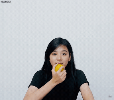 A Girl In A Black Shirt Is Holding A Yellow Object GIF