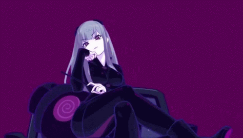 A Girl In A Black Suit Is Sitting On A Purple Couch GIF