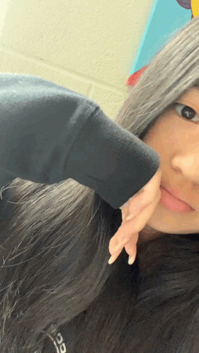 A Girl In A Black Sweatshirt Is Taking A Selfie GIF