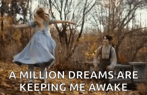 A Girl In A Blue Dress Is Dancing In The Woods Next To A Man . GIF