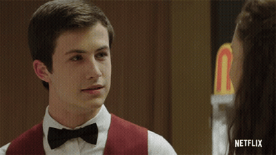A Girl In A Bow Tie Is Smiling In Front Of A Netflix Sign GIF