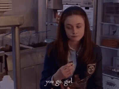 A Girl In A Chelton Uniform Is Holding A Bowl Of Chocolate GIF