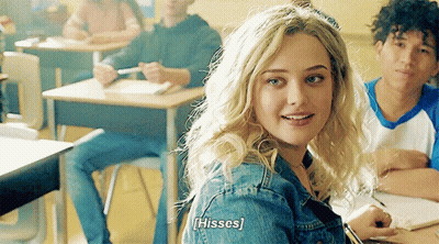 A Girl In A Classroom With The Word Hisses Written On Her Back GIF