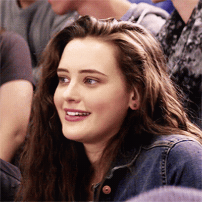 A Girl In A Denim Jacket Is Smiling In A Crowd GIF