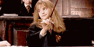 A Girl In A Harry Potter Uniform Is Holding A Wand In Her Hand GIF