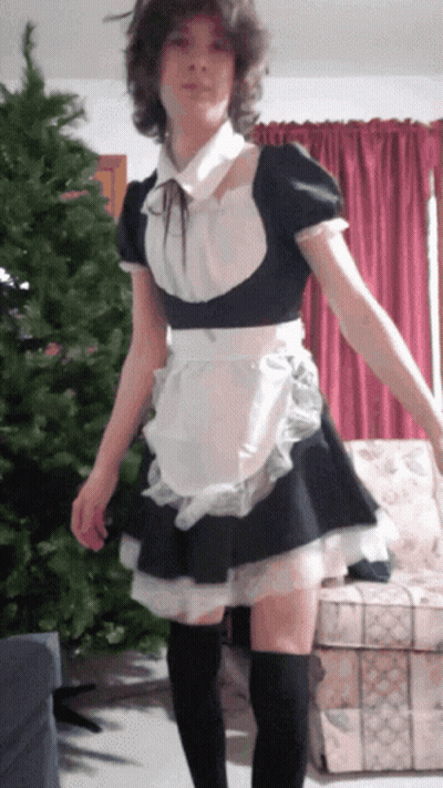 A Girl In A Maid Costume Is Standing In Front Of A Couch GIF