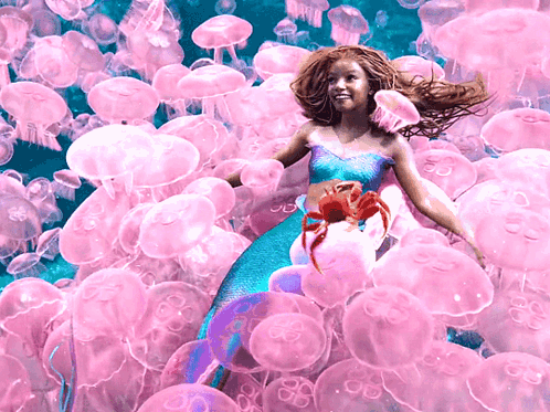 A Girl In A Mermaid Costume Is Surrounded By Jellyfish GIF