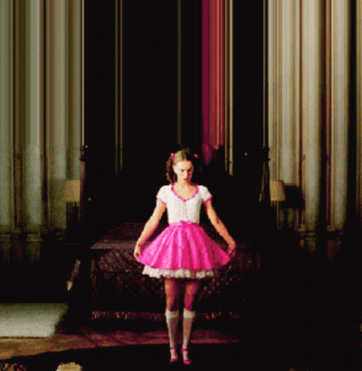 A Girl In A Pink Dress Is Standing In A Room GIF