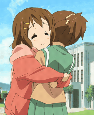A Girl In A Pink Hoodie Is Hugging Another Girl In A Green Skirt GIF