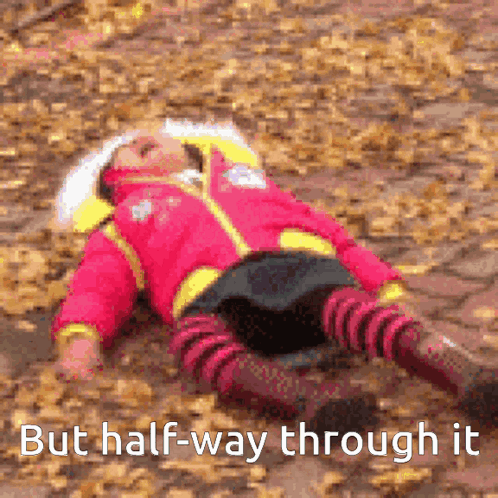 A Girl In A Pink Jacket Is Laying On The Ground With The Words But Half-Way Through It Below Her GIF