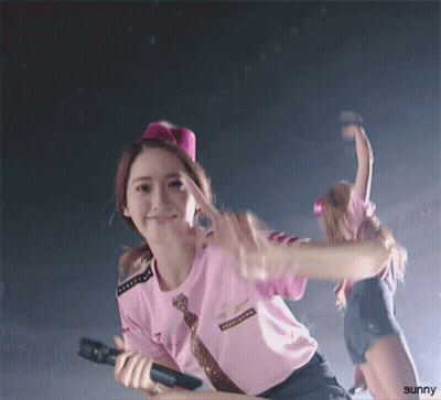 A Girl In A Pink Shirt Is Holding A Microphone And The Word Sunny Is On The Bottom GIF