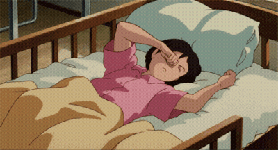 A Girl In A Pink Shirt Is Laying In A Bed And Rubbing Her Eyes GIF