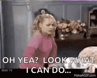 A Girl In A Pink Shirt Is Standing In A Kitchen And Saying `` Oh Yea ? Look What I Can Do . '' GIF