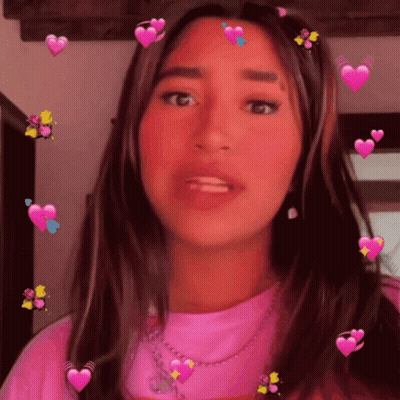 A Girl In A Pink Shirt With Hearts On Her Hair GIF