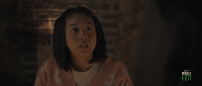 A Girl In A Pink Sweater Is Smiling In A Project Exit Advertisement GIF