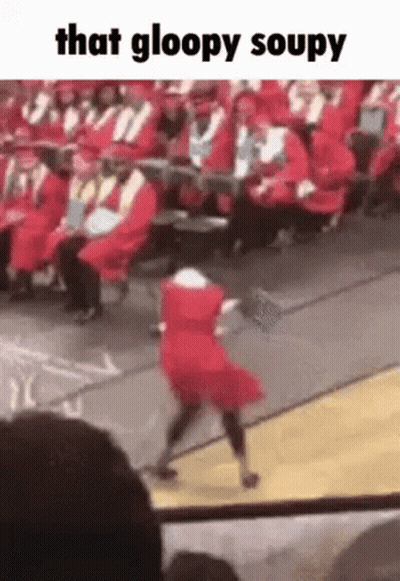 A Girl In A Red Dress Is Dancing On A Stage At A Graduation Ceremony . GIF