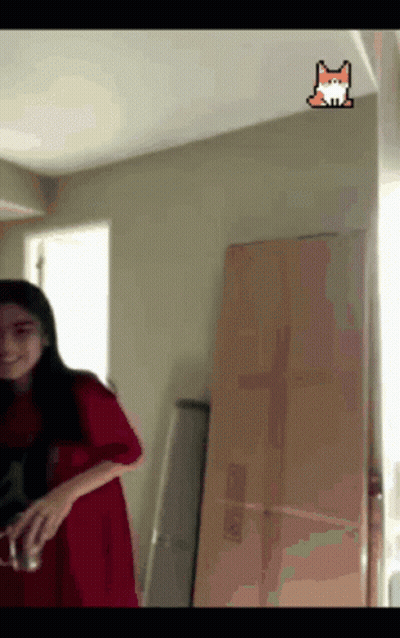 A Girl In A Red Dress Is Standing In A Room With A Fox Sticker On The Ceiling GIF