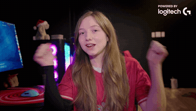 A Girl In A Red Shirt Is Dancing In Front Of A Computer Monitor Which Is Powered By Logitech G GIF