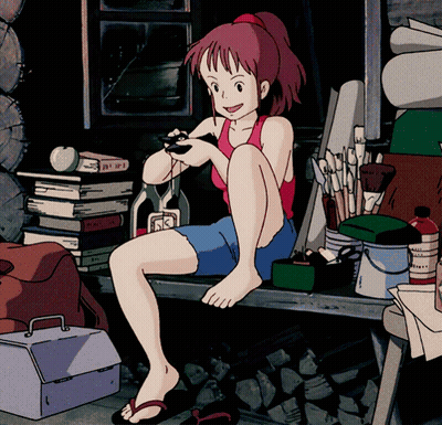 A Girl In A Red Tank Top Sits On A Bench Holding A Remote Control GIF