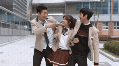 A Girl In A School Uniform Is Being Held By Two Boys GIF