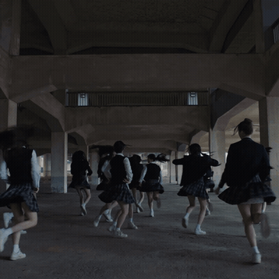 A Girl In A School Uniform Is Dancing With Her Hands In The Air GIF