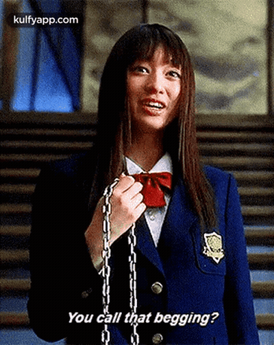 A Girl In A School Uniform Is Holding A Chain Around Her Neck . GIF