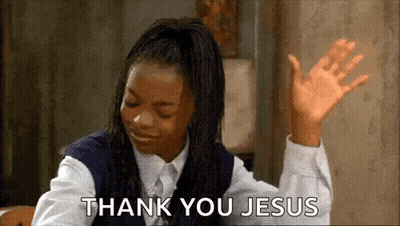 A Girl In A School Uniform Is Sitting At A Table With Her Hands In The Air And Saying `` Thank You Jesus '' . GIF