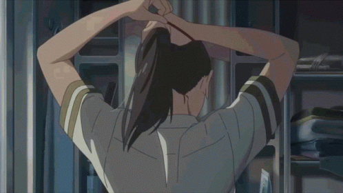 A Girl In A School Uniform With A Red Bow On Her Shirt Is Tying Her Hair Up GIF