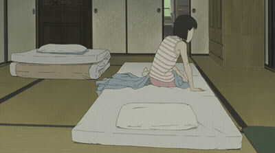 A Girl In A Striped Shirt Sits On A Mattress In A Room GIF
