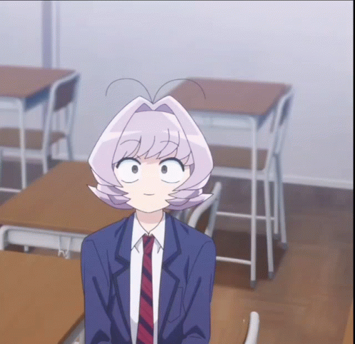 A Girl In A Suit And Tie Is Sitting At A Desk In A Classroom GIF