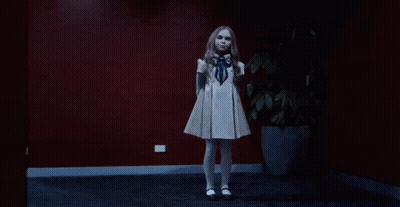 A Girl In A White Dress Is Dancing In A Dark Room GIF