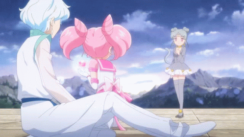 A Girl In A White Dress Is Standing Next To A Boy In A White Suit GIF