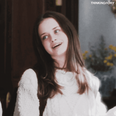 A Girl In A White Sweater Is Smiling With The Words Thinkingrory Behind Her GIF