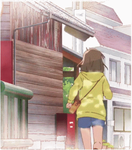 A Girl In A Yellow Hoodie And Shorts Is Walking Down A Street GIF
