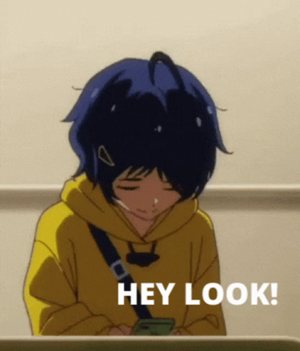 A Girl In A Yellow Hoodie Is Looking At Her Phone And Says Hey Look ! GIF