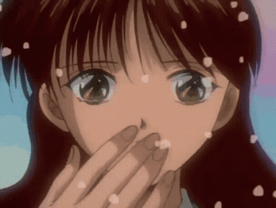 A Girl Is Covering Her Mouth With Her Hand And Petals Are Falling From Her Hair GIF