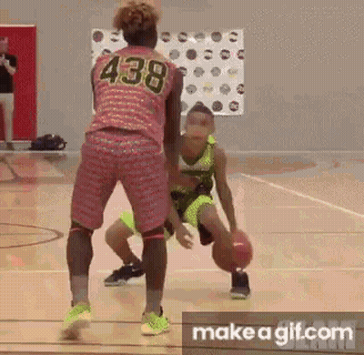 A Girl Is Dribbling A Basketball On A Basketball Court While Another Girl Tries To Stop Her . GIF