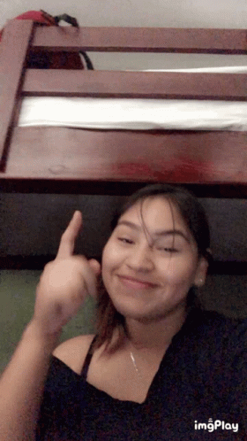 A Girl Is Giving The Middle Finger In Front Of A Bunk Bed .. GIF