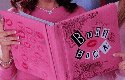 A Girl Is Holding A Pink Burn Book With Kisses On It GIF