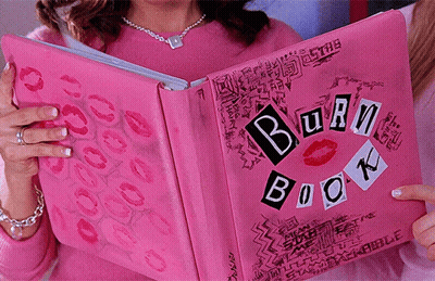 A Girl Is Holding A Pink Burn Book With Kisses On It GIF