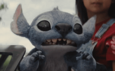 A Girl Is Holding A Stuffed Animal With Big Eyes And Teeth GIF