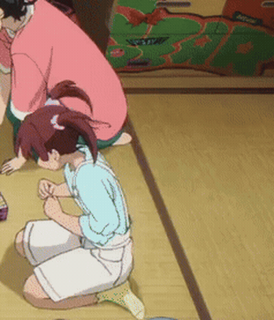A Girl Is Kneeling Down On The Floor While A Man Sits Behind Her GIF