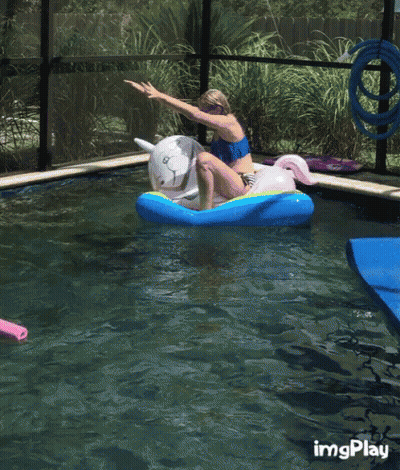 A Girl Is Riding A Unicorn Float In A Pool GIF